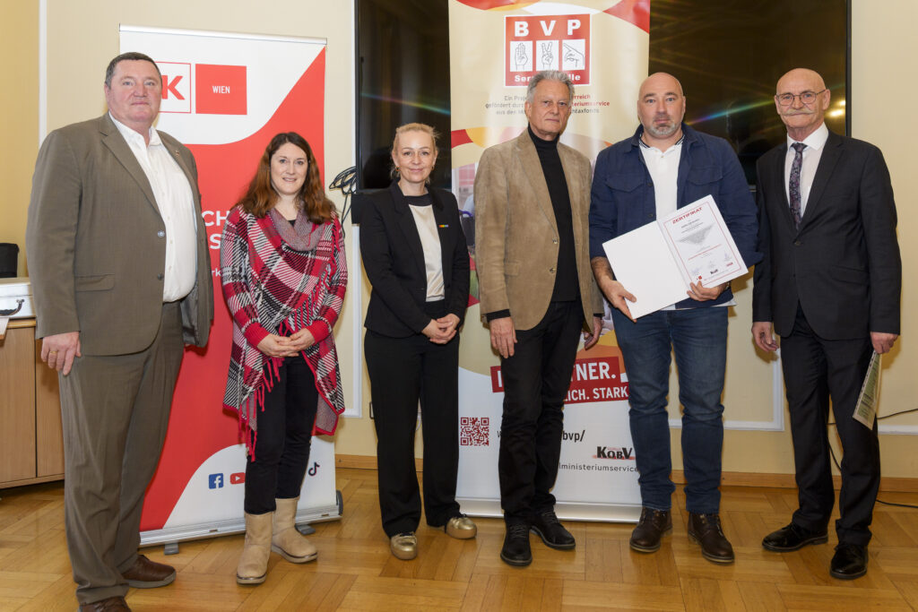 Gruppenfoto mit sechs Personen, von denen eine ein Zertifikat in der Hand hat.