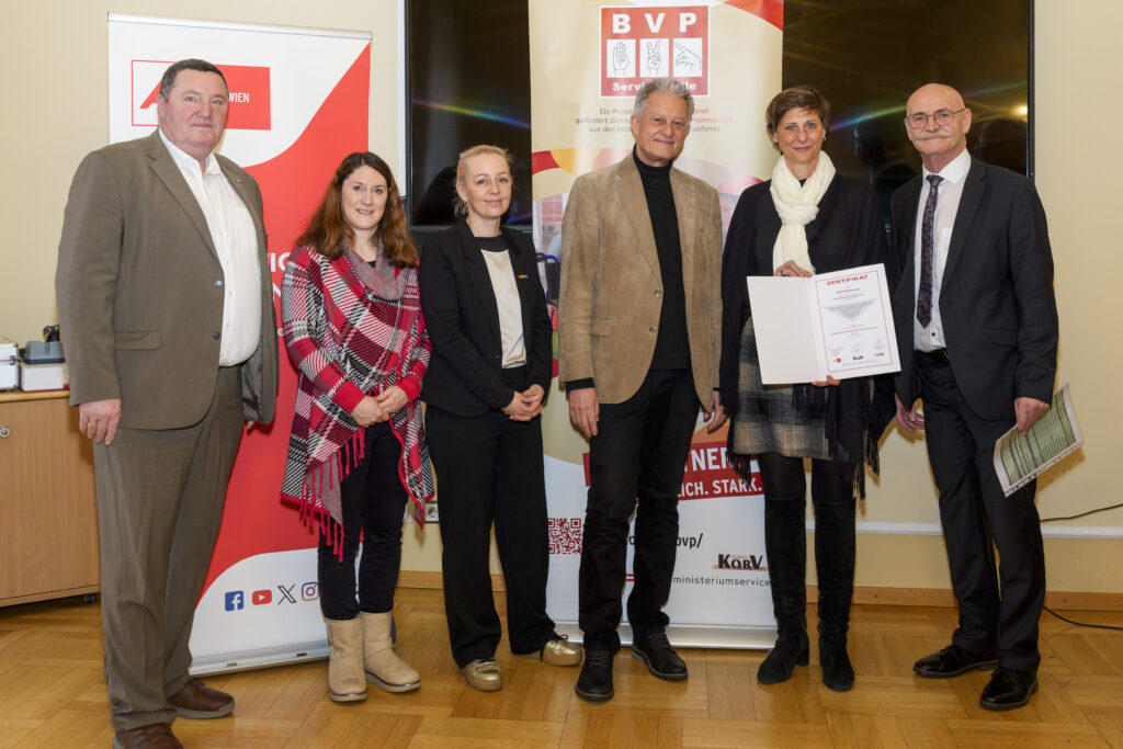 Gruppenfoto mit sechs Personen, von denen eine ein Zertifikat in der Hand hat.