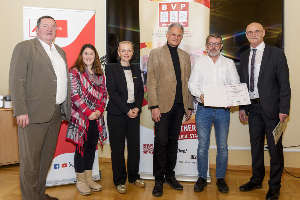 Gruppenfoto mit sechs Personen, von denen eine ein Zertifikat in der Hand hat.
