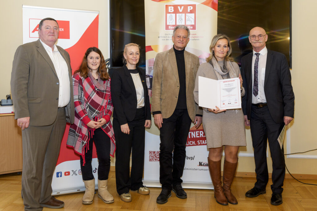 Gruppenfoto mit sechs Personen, von denen eine ein Zertifikat in der Hand hat.