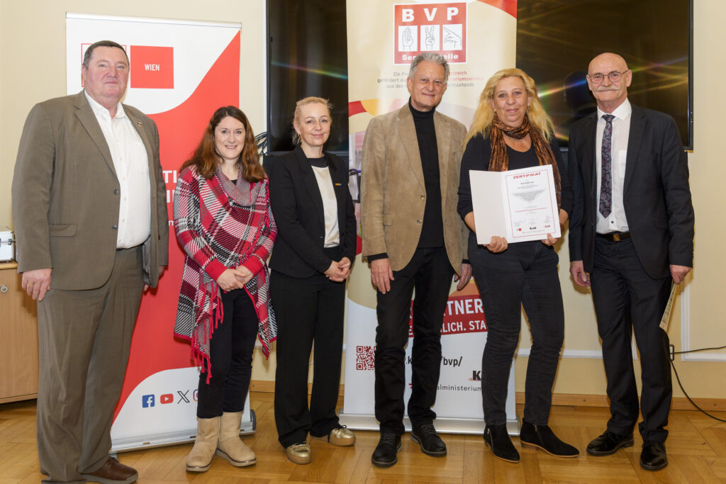 Gruppenfoto mit sechs Personen, von denen eine ein Zertifikat in der Hand hat.