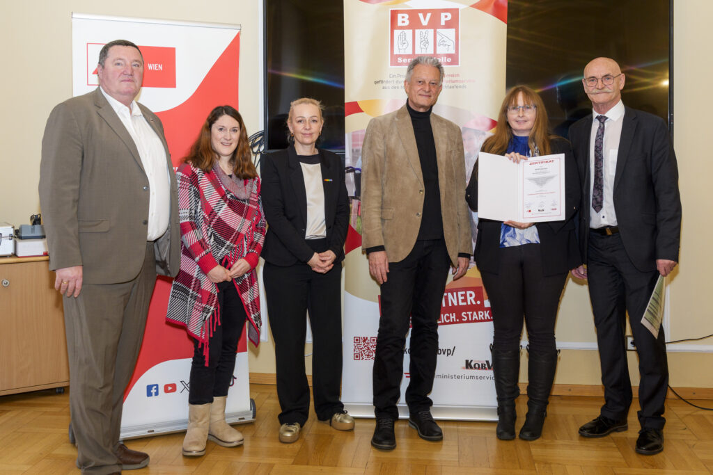 Gruppenfoto mit sechs Personen, von denen eine ein Zertifikat in der Hand hat.