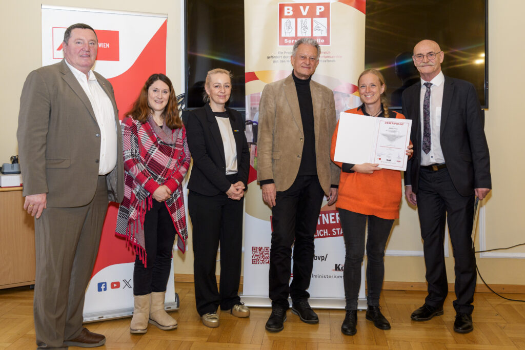 Gruppenfoto mit sechs Personen, von denen eine ein Zertifikat in der Hand hat.