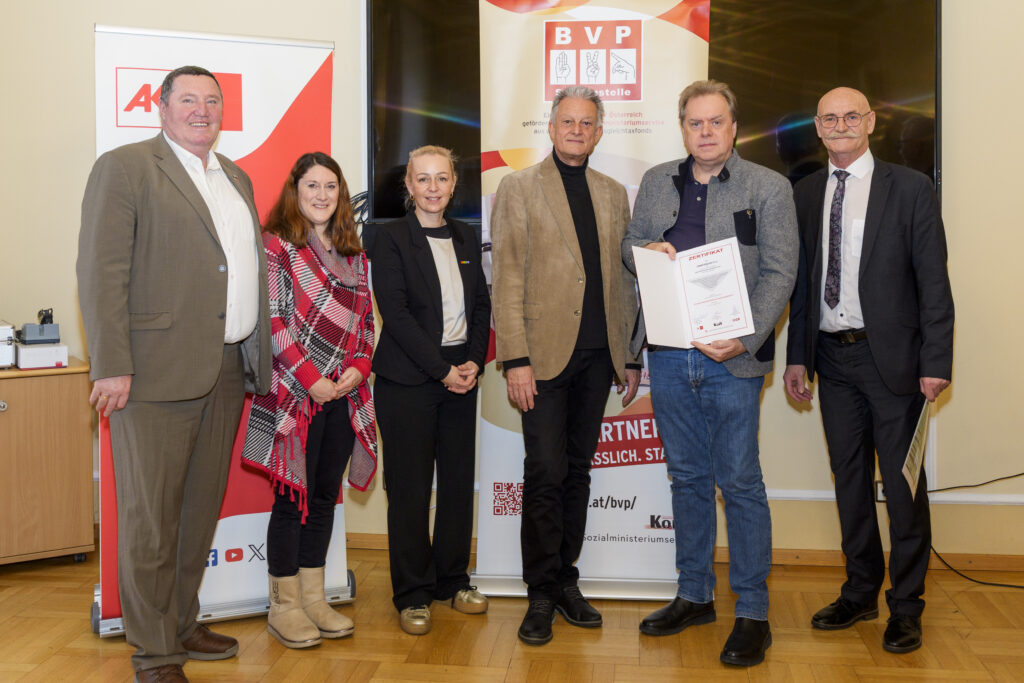 Gruppenfoto mit sechs Personen, von denen eine ein Zertifikat in der Hand hat.