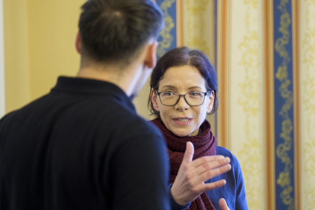 Eine Frau unterhält sich mit einem Mann und gestikuliert dabei.
