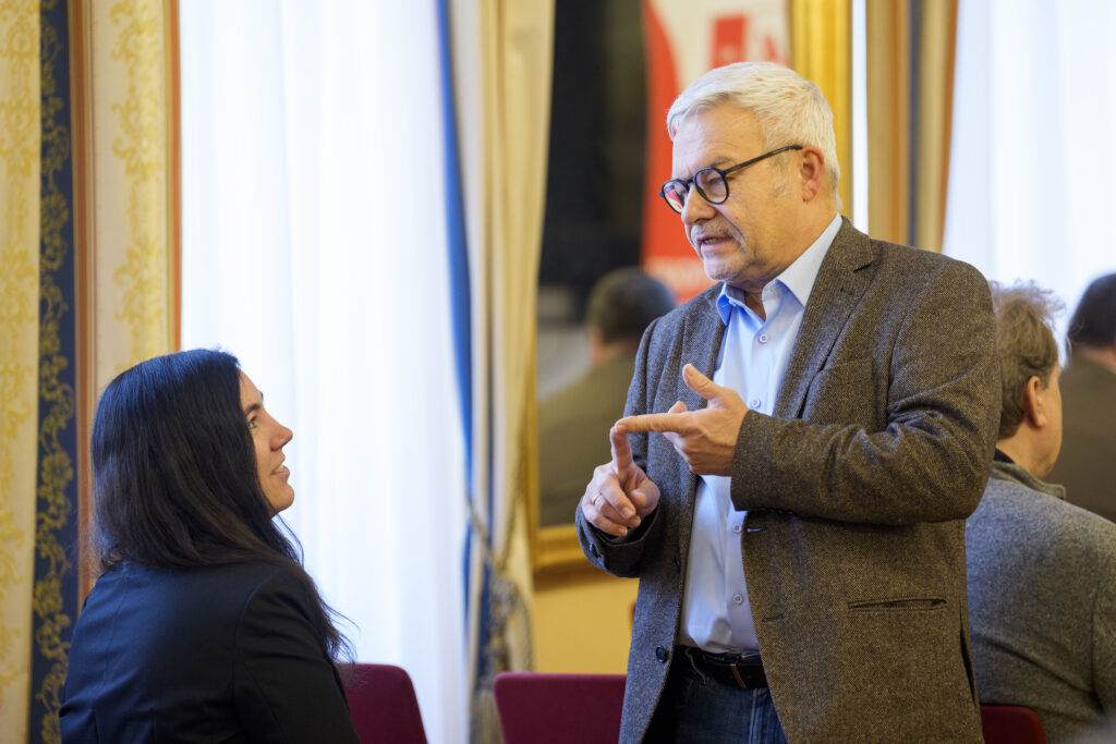 Ein Mann unterhält sich mit einer Frau und gestikuliert dabei.